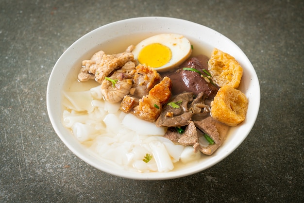 paste of rice flour or boiled Chinese pasta square with pork in clear soup - Asian food style