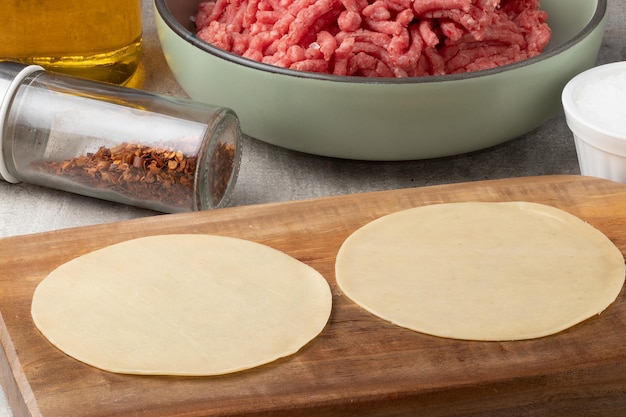 Pastel dough on cutting board. Brazilian snack made with meat or cheese.