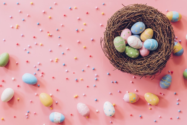 Pastel Easter eggs on pink background top view with natural light. Flat lay style.