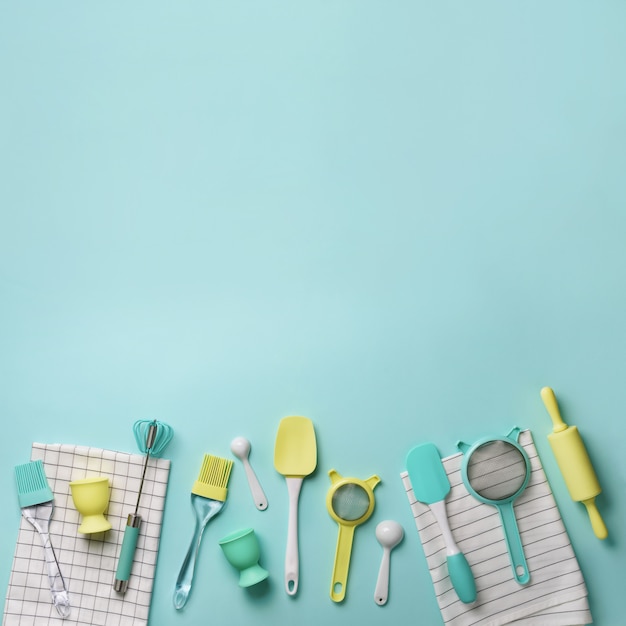 Pastel yellow, blue cooking utensils on turquoise background. Food ingredients. Cooking cakes and baking bread concept.