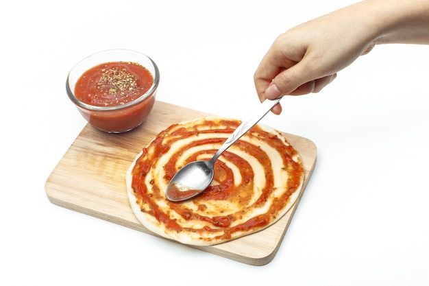 Pasting pizza sauce on pizza dough 