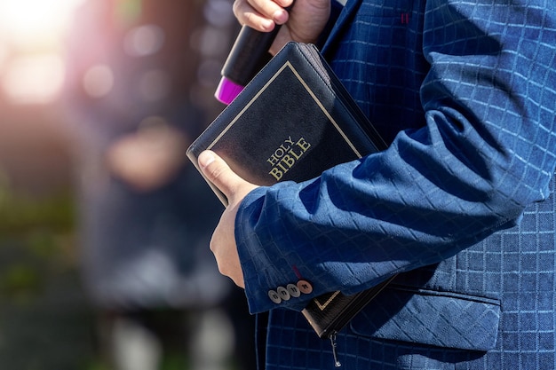 Pastor with a Bible in his hand during a sermon. The preacher delivers a speech