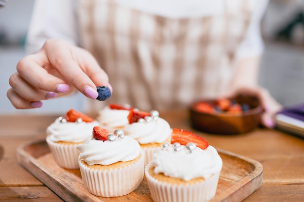 Pastry chef confectioner young caucasian woman with cake on kitchen table