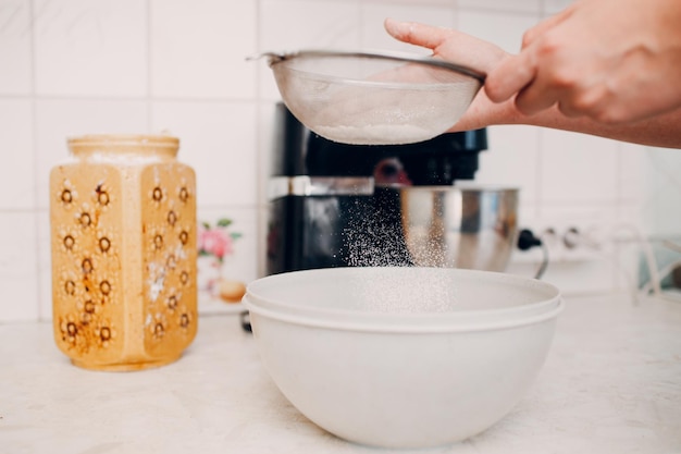 Pastry chef sift pours flour makes cake Cooking and preparing dessert