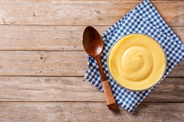 Pastry cream in a bowl on wooden table