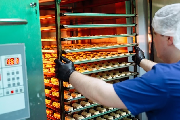 Pastry man takes out of the oven ready-made Shortbread Cookies.