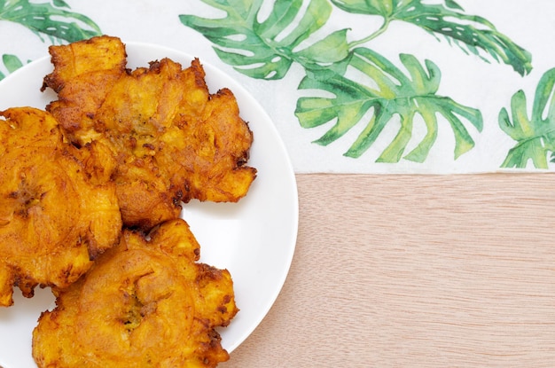 Patacones or fried tostones of green or ripe plantainith hogado