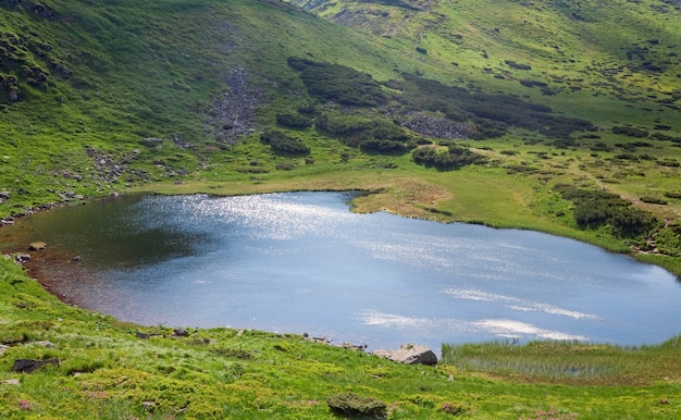 Patch of sunlight on Alpine lake Nesamovyte surface (Ukraine, summer mountain Chornogora Ridge, Carpathian Mountains)