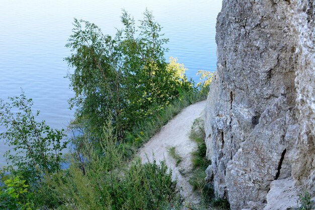 Photo a path is in the mountains with the river on background