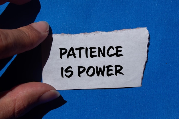 Photo patience is power message written on ripped torn paper with blue background conceptual patience is power symbol copy space