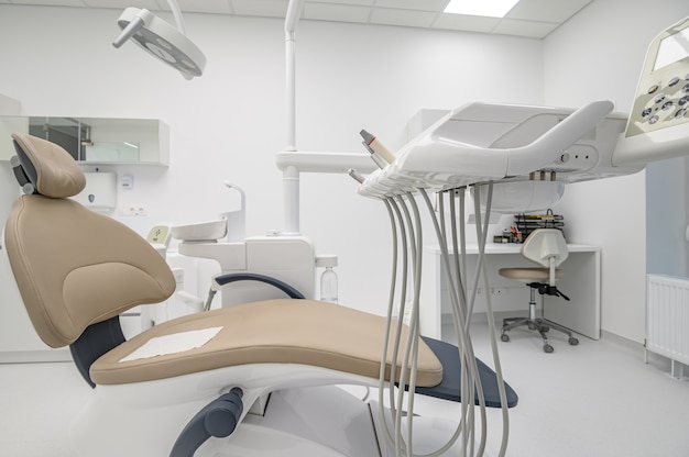 Patient chair in Interior of white modern dentistry medical room with special equipment