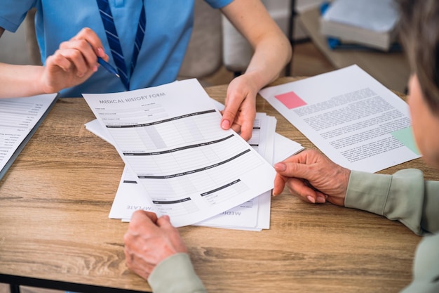 Photo patient checking medical records reading and signing document at doctor office