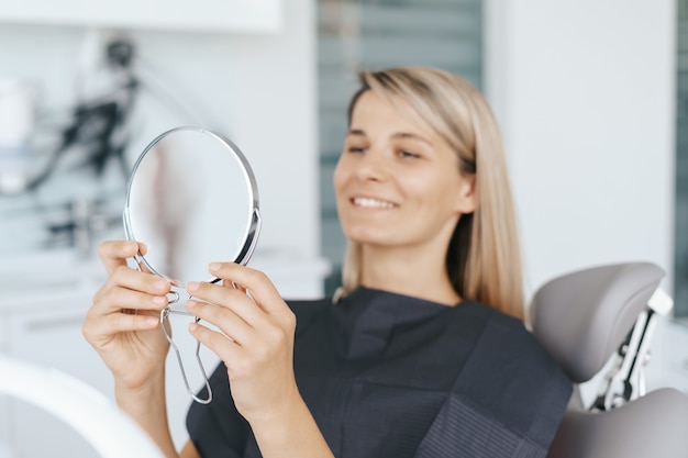 Patient looking to her smile in the mirror after treatment.