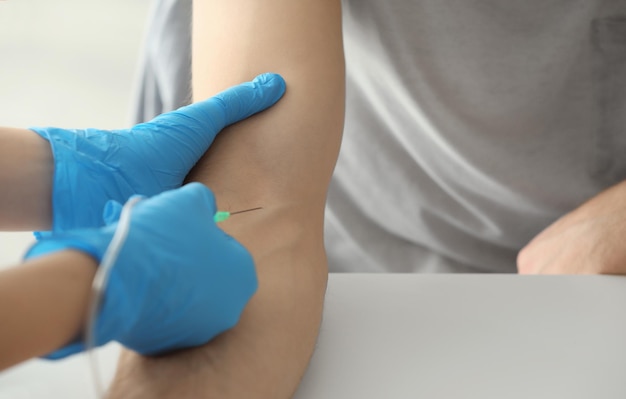 Patient receiving injection from medical assistant in clinic closeup