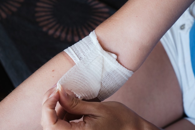 The patient removes the dressing covering the wound from the medical needle puncture on his own.