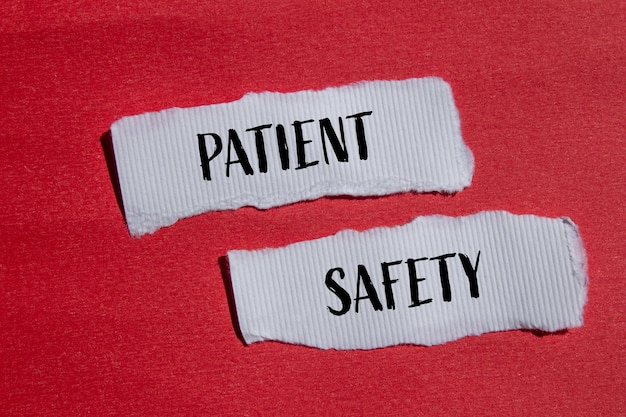 Patient safety words written on ripped white paper pieces with red background Conceptual patient safety symbol Copy space