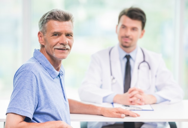 Patient sitting at doctors office and looking at camera.