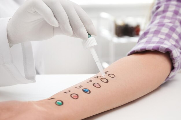 Photo patient undergoing skin allergy test at light table closeup