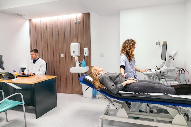 Patient undergoing an ultrasound with attentive medical professionals in a wellequipped clinic room