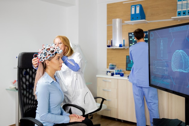 Patient who undergoes a brain scan procedure in a neurological center. Neurology scanning headset