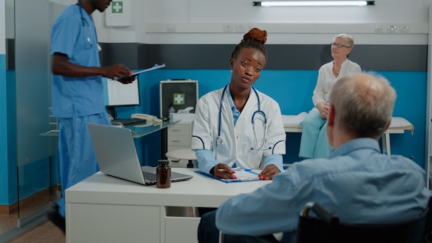 Patient with disability sitting at desk for checkup with medic