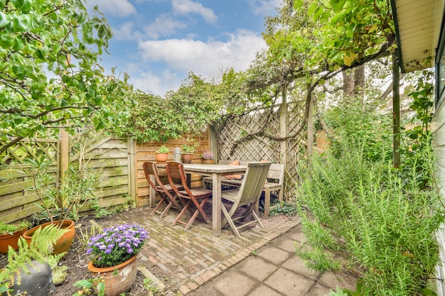 A patio with a table and chairs in a garden