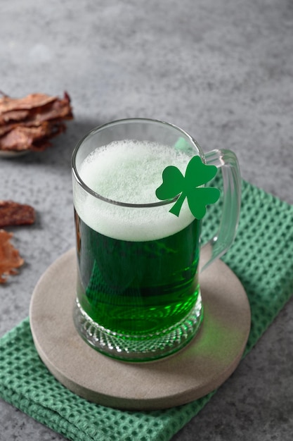 Patrick's day green beer in pint and jerky on gray background