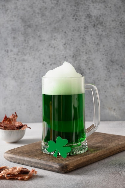 Patrick's day green beer in pint and jerky on gray background