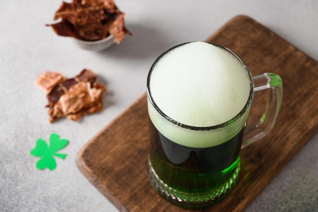 Patrick's day green beer in pint and jerky on gray background