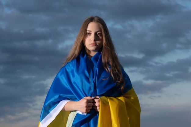 Patriotic teen ukrainian child with national flag of ukraine