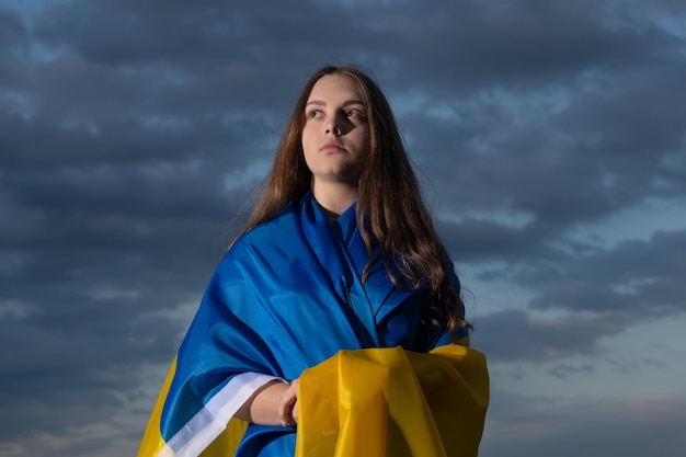 Patriotic teen ukrainian girl with national flag of ukraine