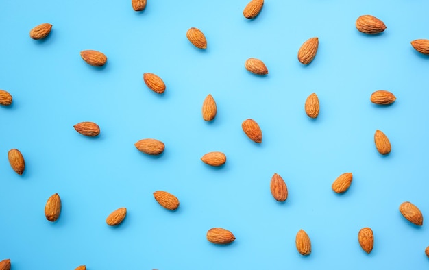 pattern of almonds nuts arrange on blue background