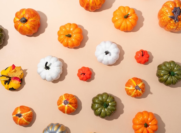 Pattern of colorful artificial pumpkins on orange background