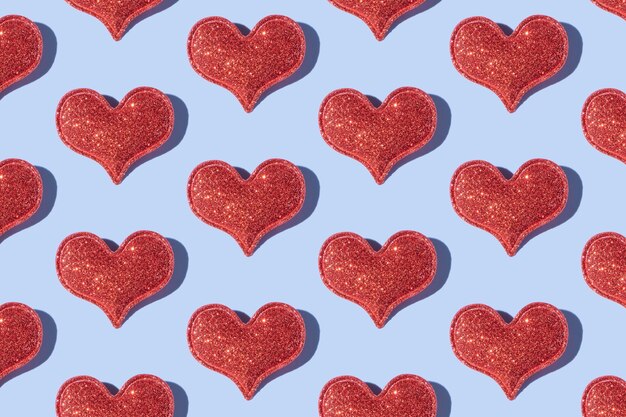 Pattern made from glitter heart shape on colored background with hard shadow Valentines day minimalistic design