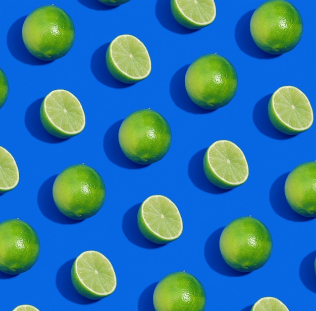 Photo pattern made with whole and cut limes on blue background bright fruit composition