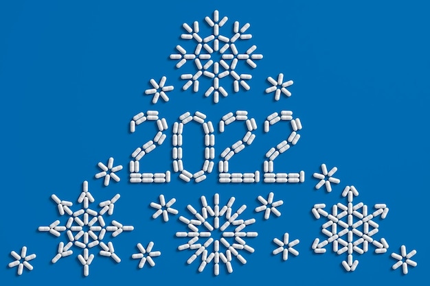 A pattern of many pills scattered on a blue background in the form of figures 2021. 3D illustration