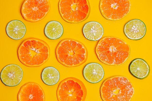 Pattern of orange fruit slice and lime slice on yellow background Cute wallpaper for summer concept