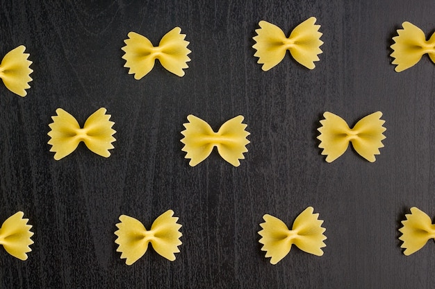 Pattern of A pile of farfalle pasta on black background