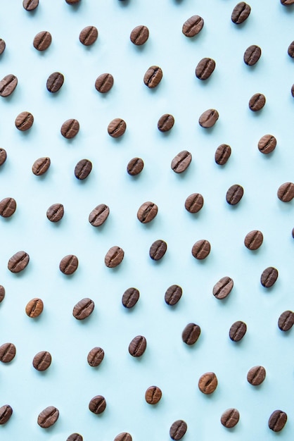 Pattern of roasted coffee beans on a blue background top view