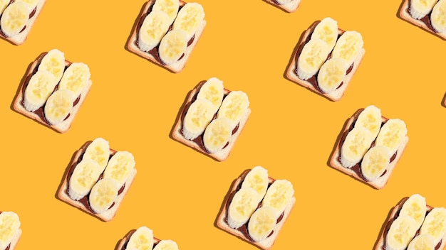 Pattern of toasted bread with banana and chocolate on yellow background