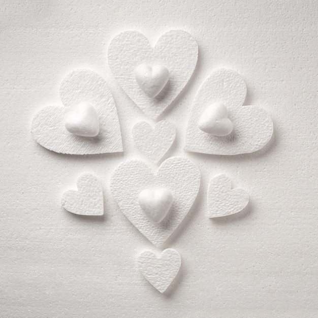 Pattern of white styrfoam hearts on the sheet of a white styrfoam Valentines day background