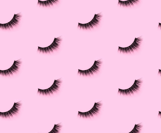 Pattern with eyelashes on pink background.  Flat lay top view