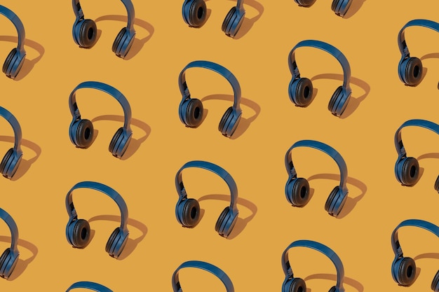 Photo pattern with headphones on a yellow background. the concept of listening to contemporary music.