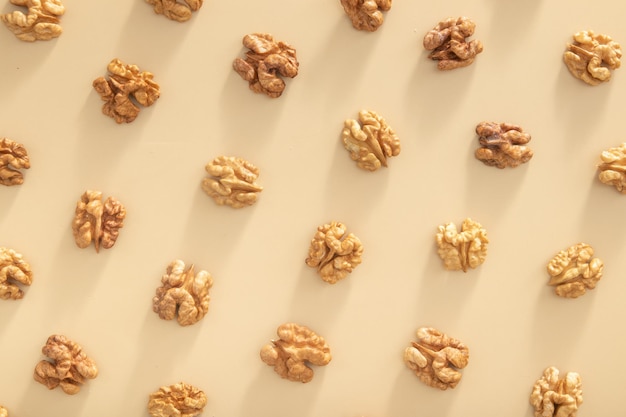 Pattern with peeled halves of walnuts top view Food abstract background with nuts