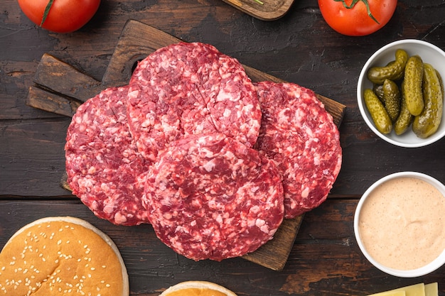 Patty of minced meat for burger set, on old dark  wooden table