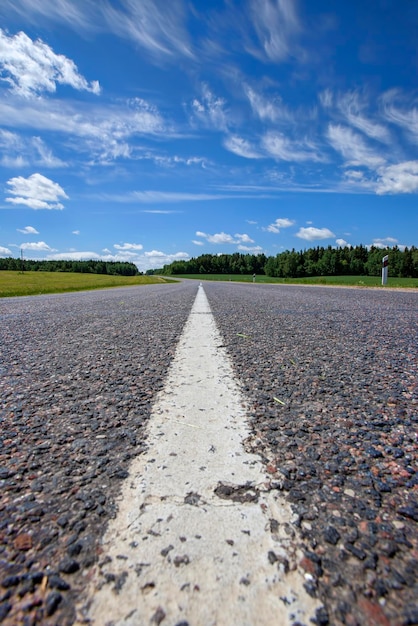 Paved highway with blue sky and clouds