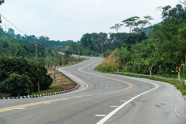 Paved road ThailandThe asphalt road on both sides of the road is covered with grass