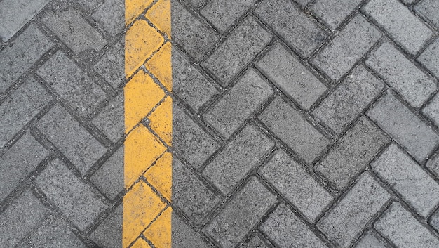 Photo paving slab gray urban street with yellow lines road markings stone tile texture background