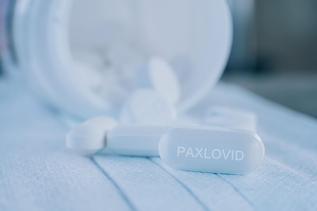 Paxlovid tablet medication for treatment Covid19, potential new drug cure for COVID 19 Corona virus closeup. Therapy for Koronavirus. Pharmaceuticals on mask.