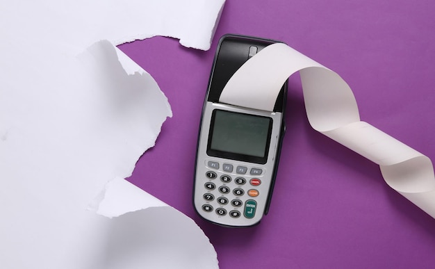 Payment terminal and white torn paper sheet on purple background Copy space Top view